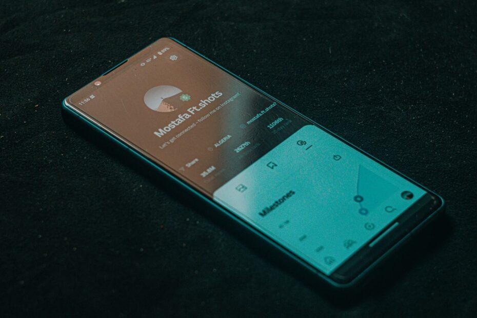 A smartphone displaying an app screen lies on a dark surface, highlighting technology.