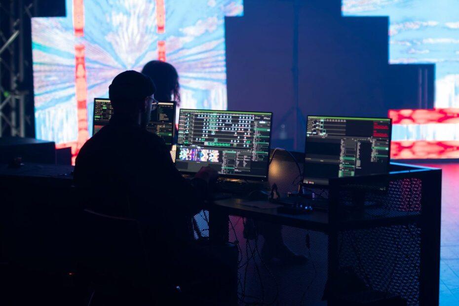 A stage technician monitors multimedia displays during a live event setup.